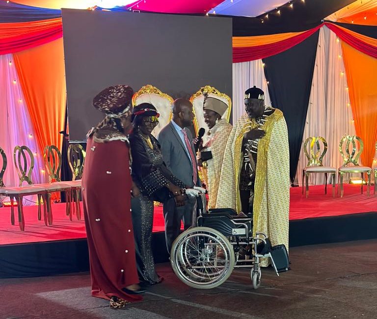 Aido Kenya Chair, Anne Hermbarger and Elisabeth Ngari chair receiving a brand new wheel chair from Mr Calton Darby